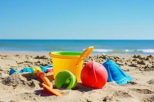 figli di giocattoli menzogna su il sabbia. piccolo mare onde siamo visibile nel il sfondo. estate riposo foto