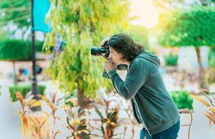 maschio fotografo assunzione fotografie nel un' pubblico parco, nagarote. fotografo assunzione fotografie su il strada