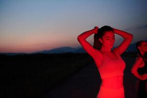 atleta scioperi un' posa nel illuminato di rosso ore notturne splendore foto