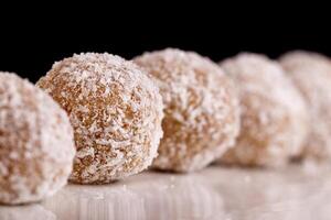 bellissimo dolci con Noce di cocco su un' bianca piatto su un' nero sfondo foto