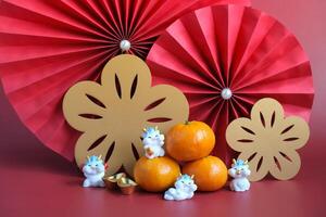 Cinese nuovo anno di il Drago Festival concetto. mandarino arancia, rosso buste, Drago e oro lingotto con rosso carta fan. Cinese personaggio da ji da li senso grande fortuna grande profitto. foto