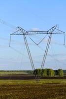 un' alta tensione energia linea su il sfondo di un' rurale campo. paesaggio nel il villaggio e elettrico cablaggio. foto