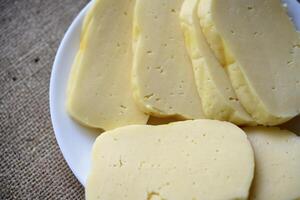 fette di formaggio tagliare su un' piatto. delizioso formaggio con buchi. foto