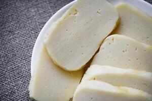 fette di formaggio tagliare su un' piatto. delizioso formaggio con buchi. foto