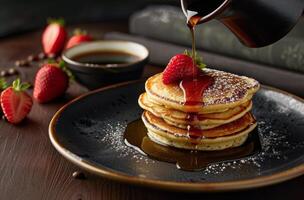 pila di Pancakes con sciroppo e fragole su un' piatto foto