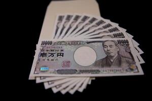 giapponese moneta 100.000 yen con Busta su il nero sfondo foto