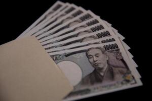 giapponese moneta 100.000 yen con Busta su il nero sfondo avvicinamento foto