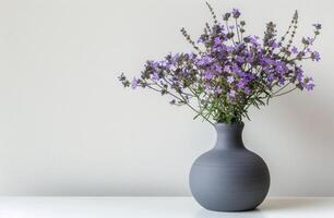 grigio vaso con viola fiori su tavolo foto