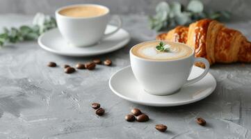 Due tazze di caffè e un' brioche su un' piatto foto