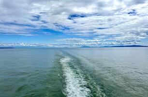 un' pista su il acqua in partenza si nave un' enorme rivestimento un' crociera nave voi può vedere il ribollendo acqua bellissimo cielo in profondità oceano in giro natura e il nave è andare in barca lontano Canada per vancouver isola traghetto foto