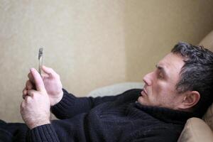 sociale media dipendente uomini su letto non dormire perché giocare inteligente Telefono, camera sfondo foto