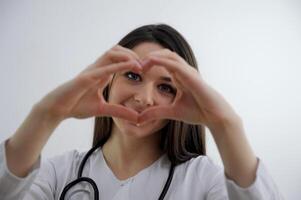 sorridente giovane ragazza mostrando cuore con Due mani, amore cartello isolato al di sopra di leggero blu sfondo ritratto giovane bellissimo donna mano Esprimere a gesti nel cuore forma Sorridi viso ragazza ottenere nel amore foto