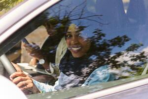 Due musulmano donne indossare hijab conversare su un' smartphone mentre in viaggio insieme nel un' auto attraverso il foto