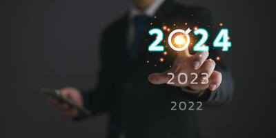 uomini d'affari toccare bersaglio 2024 e progresso di attività commerciale e analizzare finanziario, e investimento.uso tecnologia per Piano strategia per successo obiettivi e crescita.online attività commerciale, commercio elettronico, in linea marketing. foto