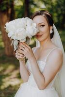 un' sposa è in posa con un' mazzo di bianca fiori foto