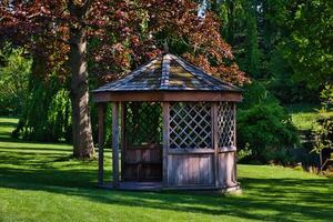 di legno gazebo nel un' lussureggiante verde giardino foto