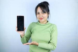 giovane bellissimo asiatico donna Tenere vuoto schermo inteligente Telefono su bianca sfondo foto
