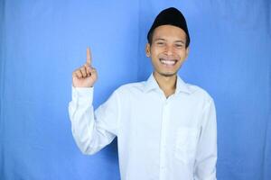 sorridente espressione di musulmano asiatico uomo, puntamento dito un vuoto spazio. pubblicità concetto foto