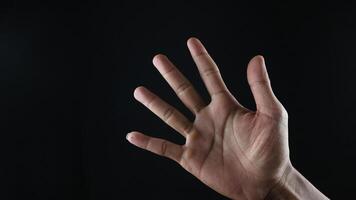 maschio mano gesto numero cinque avvicinamento isolato su un' nero sfondo foto