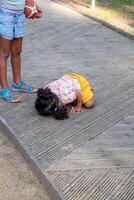 un' giovane bambino stabilisce su un' strutturato passerella, curioso, Il prossimo per un' metà visto pari. Perfetto per temi di infanzia esplorazione e all'aperto giocare a. foto