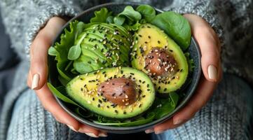 persona Tenere un' ciotola di avocado insalata con sesamo semi foto