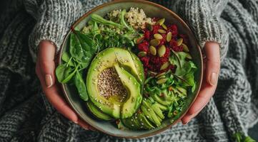 persona Tenere un' ciotola di avocado insalata con sesamo semi foto