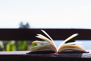 Bibbia è posto su di legno balcone su naturale sfondo dopo preghiere Dio quale è cristiano religioso rituale e credenza nel insegnamenti Dio. concetto di preghiere Dio con insegnamenti di Bibbia e attraversare. foto