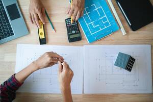 architetti e progettisti siamo parlando di costruzione piani prima essere consegnato per il ingegneria squadra e capisquadra per costruzione. revisione concetto piani a partire dal un' squadra di architetti e progettisti foto