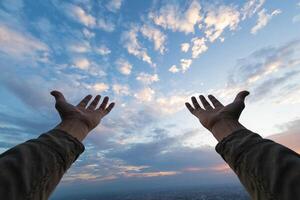 uomo sollevato sua mani sopra sua testa per Chiedi per misericordia a partire dal Dio nel conformità con sua credenza nel Dio nel cristianesimo. uomo raccolta tutti e due mani per Chiedi per benedizioni a partire dal Dio secondo per credenze foto