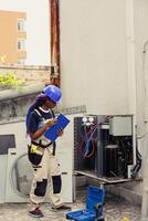 efficiente tecnico commissionato per ottimizzare HVAC sistema prestazione, garantendo esso opera a massimo efficienza. condito meccanico fare aria condizionatore verifica, imputando dati su appunti foto