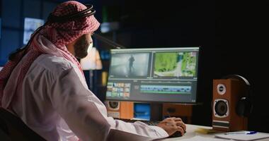 Arabo colorista libero professionista la modifica esternalizzazione cinematografico progetto, la creazione di soddisfare creazione azione filmato, Lavorando con immagini e suoni. telelavoro lavoratore in lavorazione film su pc stazione di lavoro foto