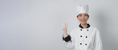 chef donna asiatica che tiene in mano uno smartphone o un tablet digitale e ha ricevuto l'ordine da online foto