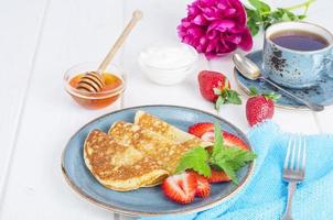 colazione gourmet. frittelle fritte dolci deliziose con fragole fresche. foto