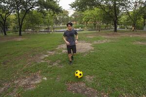 maschio calcio Giocatori pratica utilizzando il palla nel il parco campo diligentemente e felicemente. foto