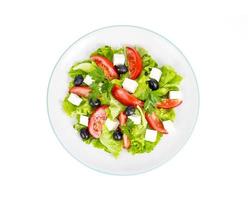 uno stile di vita sano. insalata di dieta di verdure con olive e formaggio di capra su sfondo bianco. foto