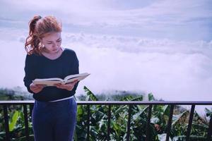 le donne si rilassano leggere il libro del mattino bel tempo cielo nebbia. in montagna, l'atmosfera mattutina. foto