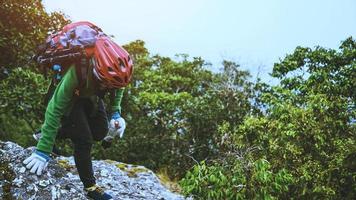 le donne asiatiche viaggiano fotografare la natura. viaggio relax nella vacanza passeggiata nella foresta. su una scogliera rocciosa. Tailandia foto