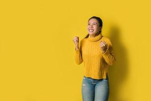 ritratto di una donna asiatica felice che urla un successo eccitato e celebrante isolato su sfondo giallo. avere successo foto