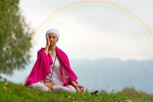 ragazza che pratica yoga nel prato foto