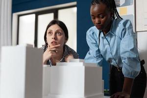 donne della professione di architetto in piedi alla scrivania dell'ufficio foto