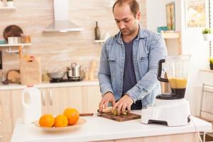 il ragazzo prepara un frullato nutriente foto