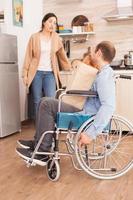 uomo disabile in sedia a rotelle con generi alimentari freschi foto