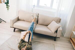 rilassante su un' accogliente moderno divano. un' contento donna godendo un' tranquillo, calmo vacanza nel un' confortevole appartamento foto