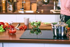 processo di cottura in cucina - casseruola, verdure sul tavolo. foto