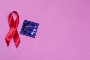 vista dall'alto su sfondo rosa con nastro rosso e concetto conservatore 1° dicembre giornata internazionale dell'AIDS da vicino