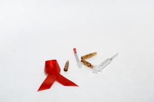 concetto medico dicembre giornata mondiale dell'AIDS. burocrazia, fiale di medicinali e siringhe su sfondo bianco. sesso sicuro foto