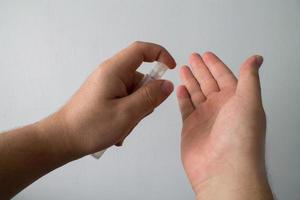 un uomo si disinfetta le mani con gel antibatterico.