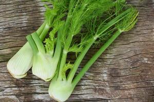 finocchio vegetale dal giardino, finocchi crudi freschi pronti da cucinare su fondo di cucina in legno di cibo. foto