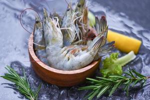 gamberi freschi in ciotola con ingredienti al rosmarino erbe e spezie per cucinare frutti di mare - gamberi crudi su ghiaccio congelati al ristorante di pesce