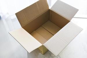 scatola di cartone aperta sullo sfondo del pavimento, vista dall'alto di una scatola di cartone vuota o di una scatola per pacchi. foto